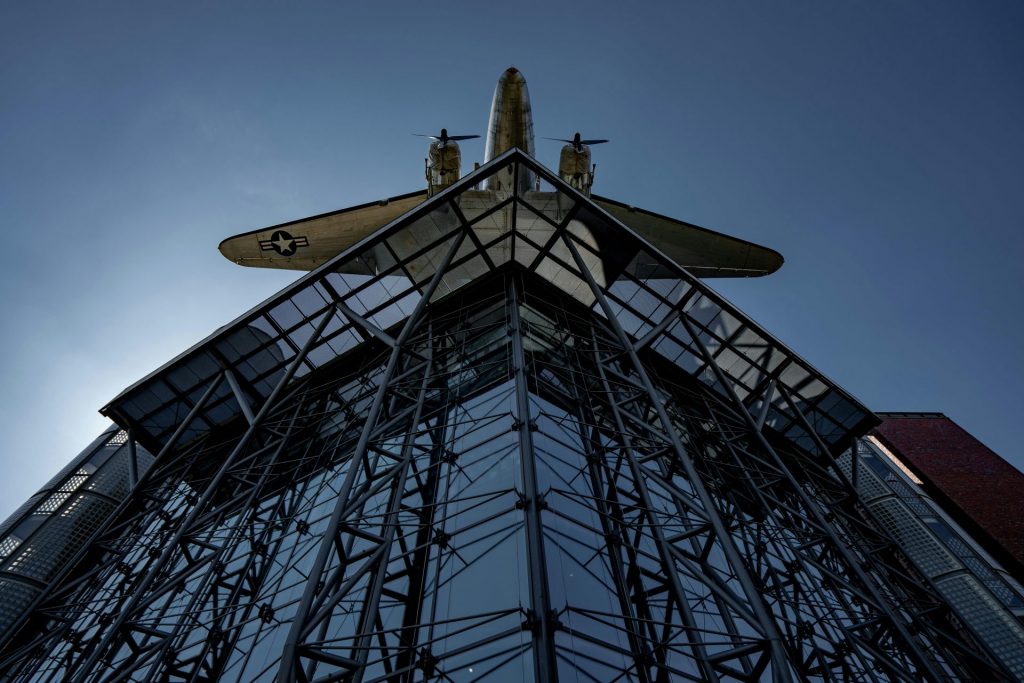 Historic aircraft displayed at a Berlin museum with striking architecture.